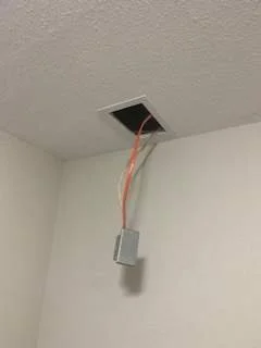 Open ceiling vent with electrical wires hanging down and a connected electrical box.