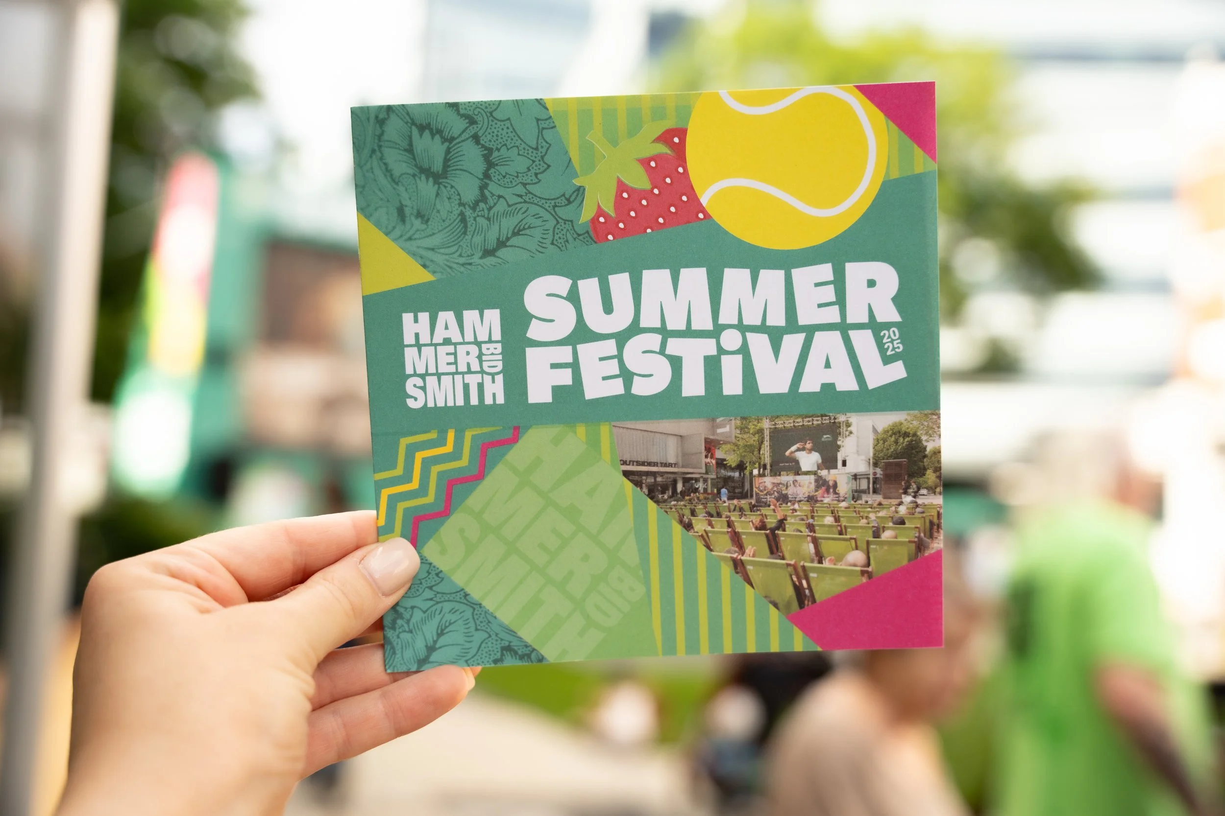 A colorful flyer for the Hamber Smith Summer Festival 2025 showing strawberries, a tennis ball, and a photo of an outdoor stage with chairs and people attending.