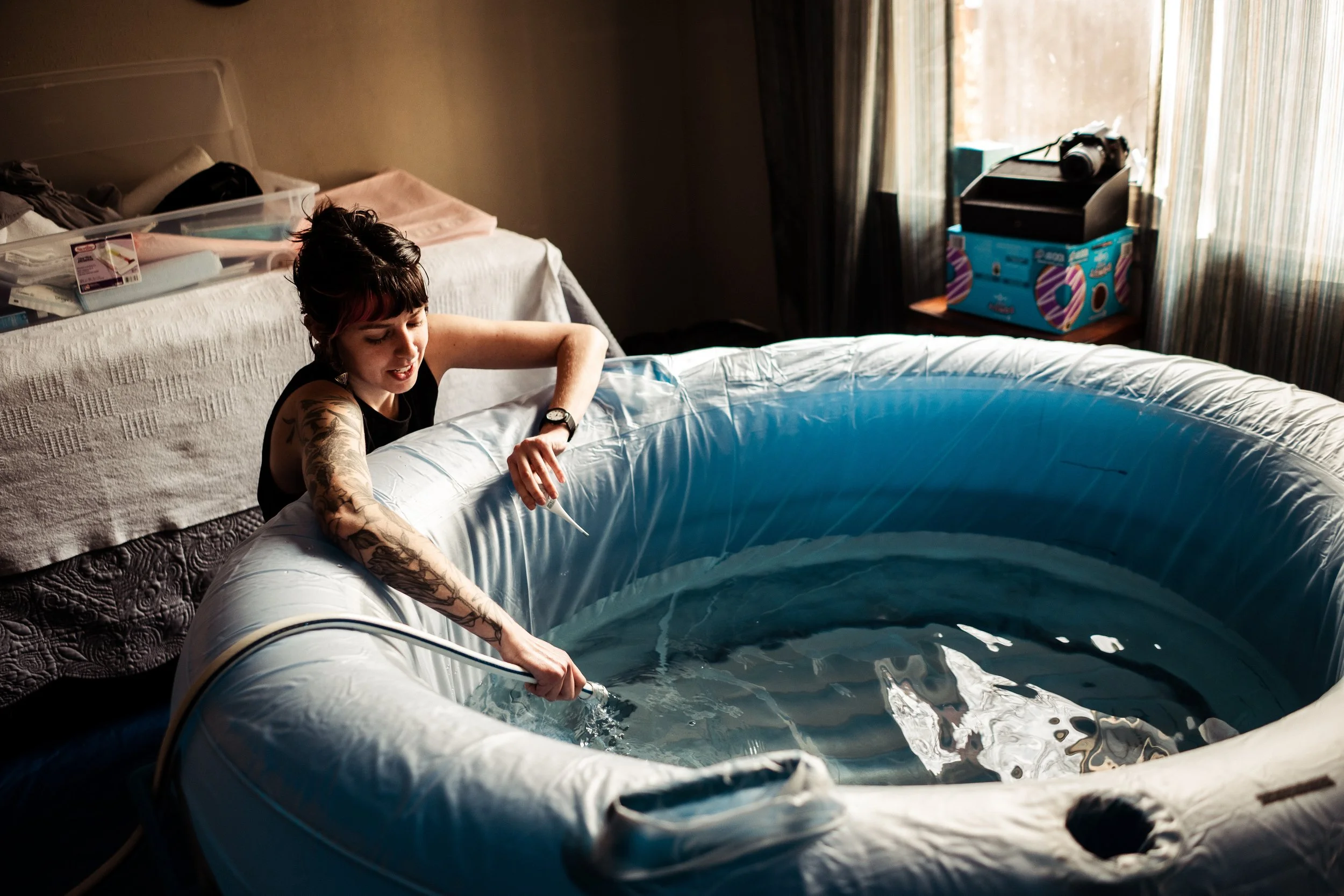 Midwife Kennedy Logan filling up a birth pool