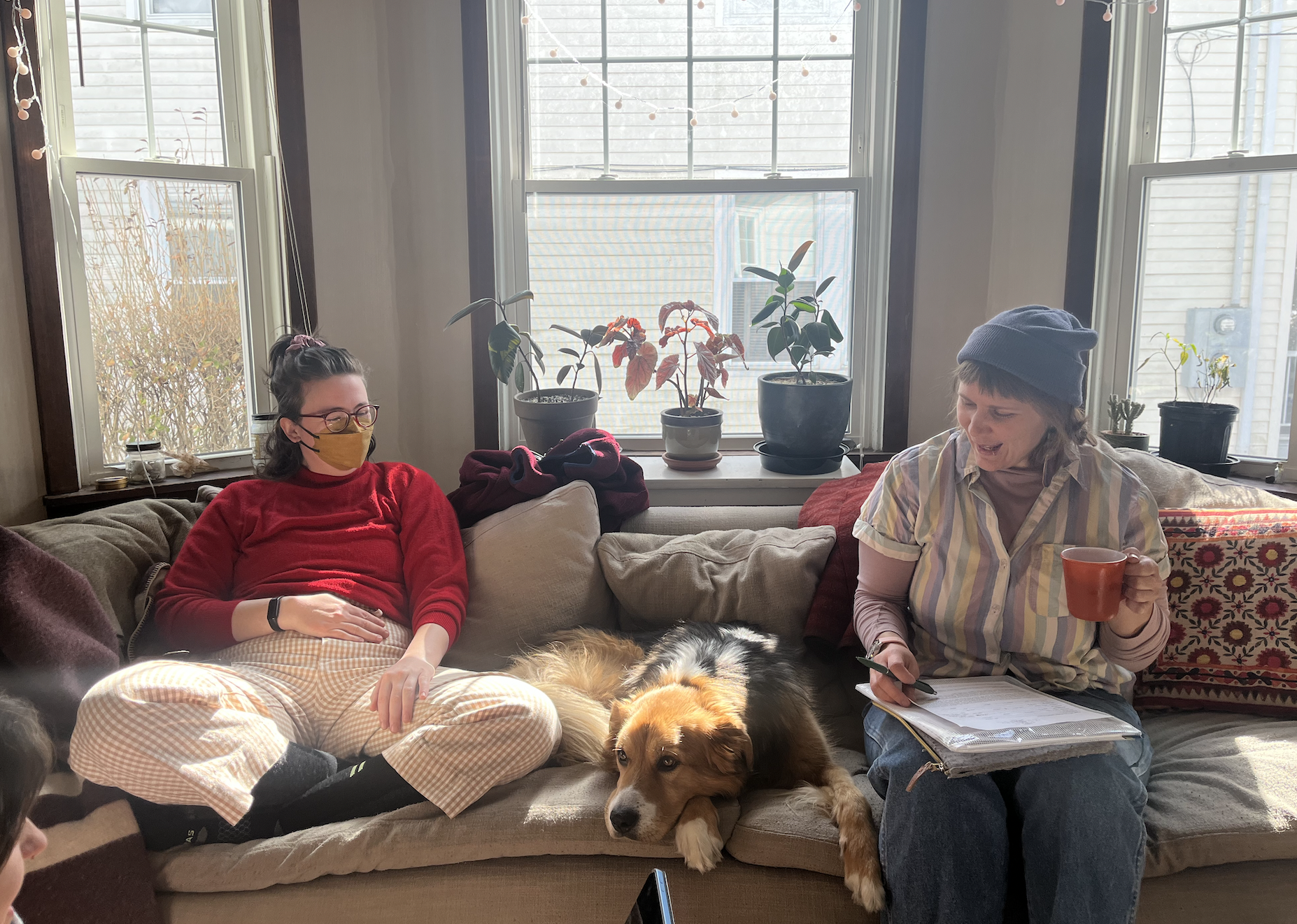 A midwife and doula sitting on a couch with a dog