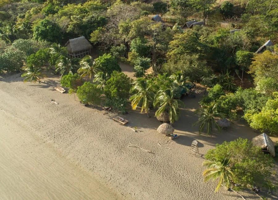 Aerial view of Eco Venayo Resort in Playa Venao, Panama of the beach, palm trees, and bungalows.