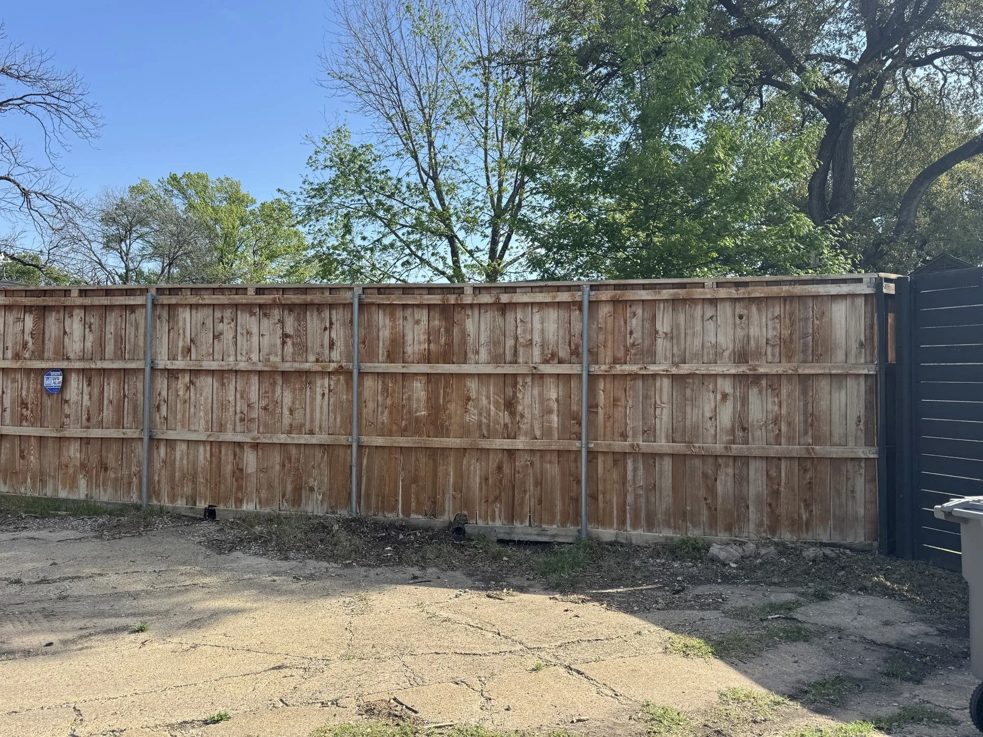 Weathered, sun-faded cedar fence before cleaning and staining at a Dallas home
