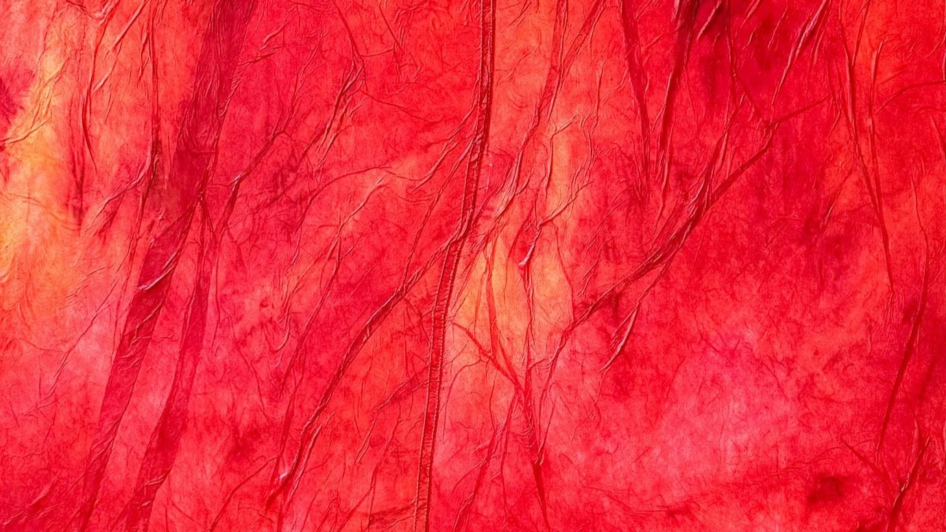 Abstract red textile surface with overdyed color, dimensional texture, and subtle orange highlights suggesting heat, movement, and organic forms.