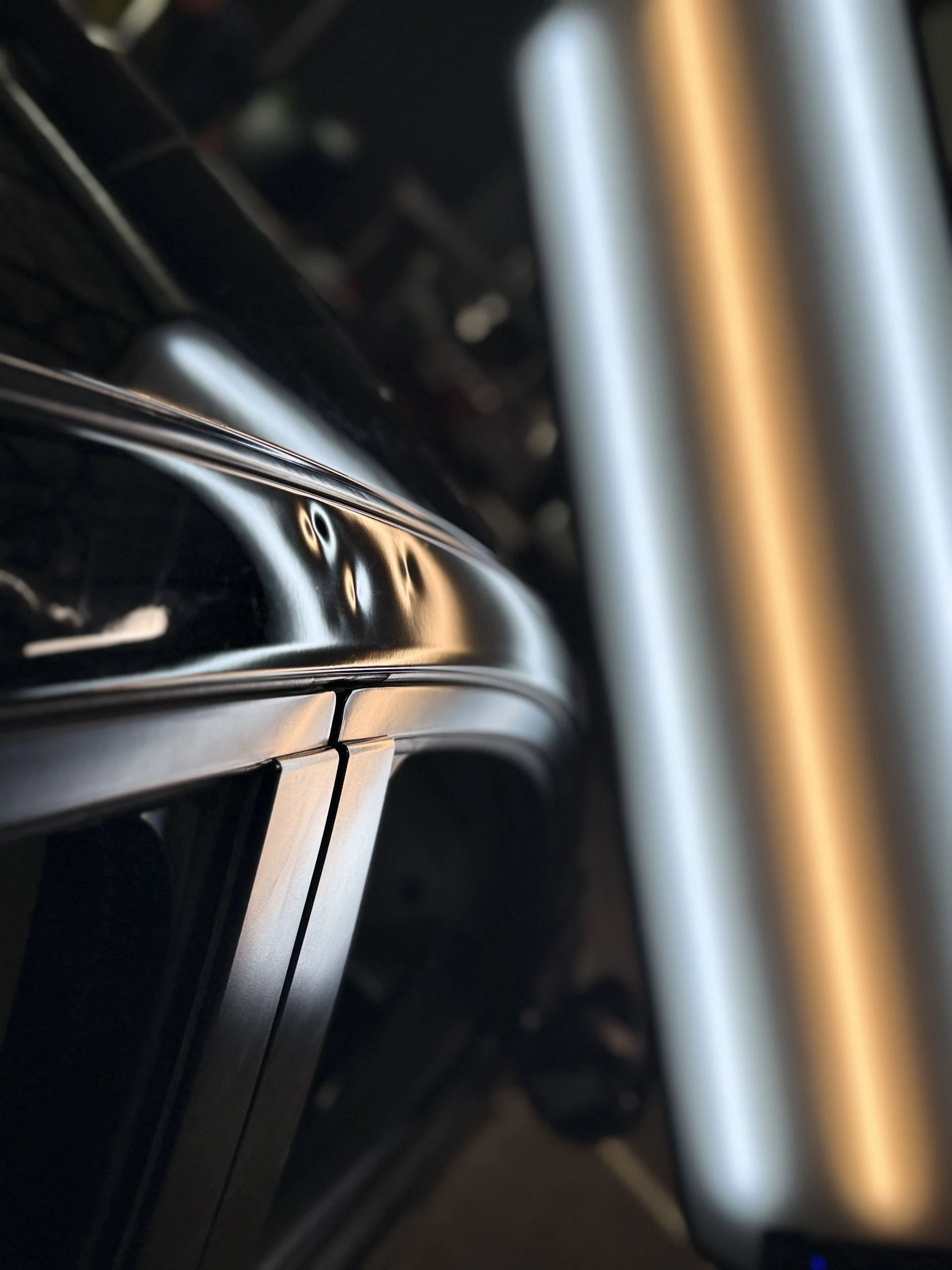 Close-up of a motorcycle fork with shiny black and metallic silver parts.