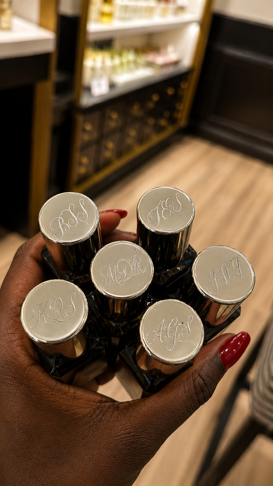 Custom fragrance bottle cap engraving during a luxury retail activation and experiential marketing event.
