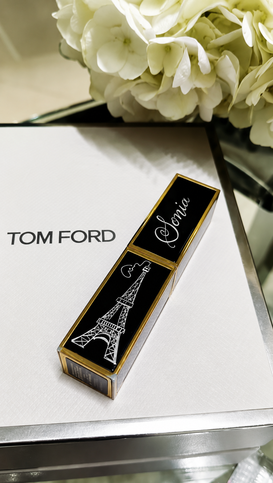 Custom lipstick engraving and luxury beauty product personalization at a retail brand activation event.