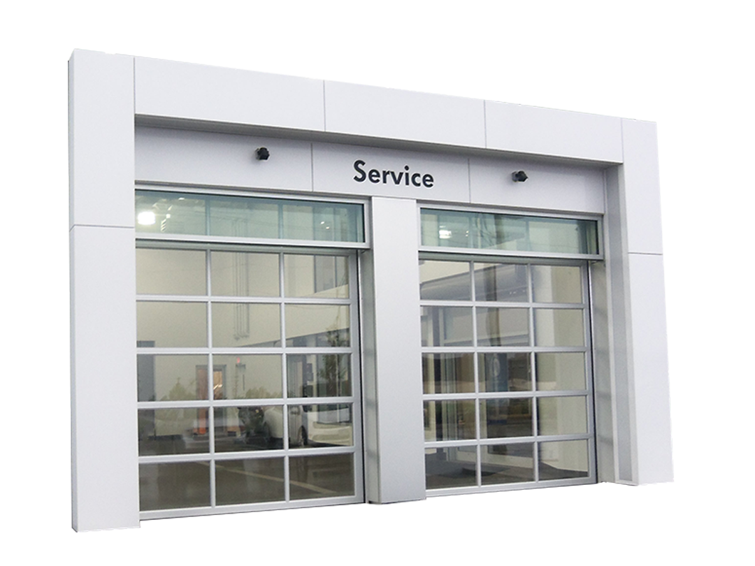 A modern drive-thru service bay with glass garage doors, white framing, and a sign that says 'Service' above the entrance.