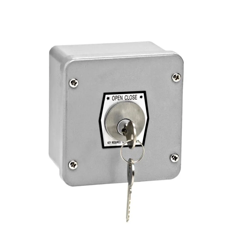 A coin-operated switch with a key, used for locking or unlocking, mounted on a gray metal box.