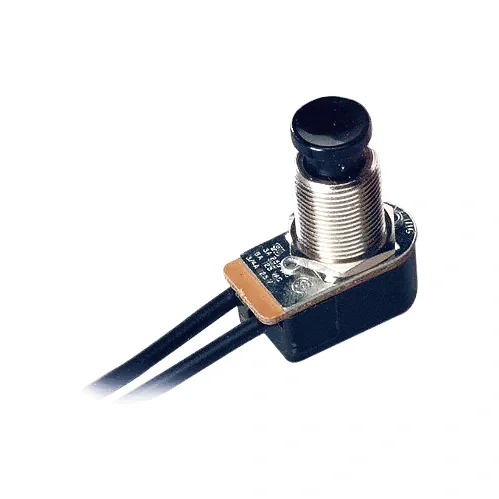 A proximity sensor with a black round top, mounted on a small circuit board with two black wires attached.