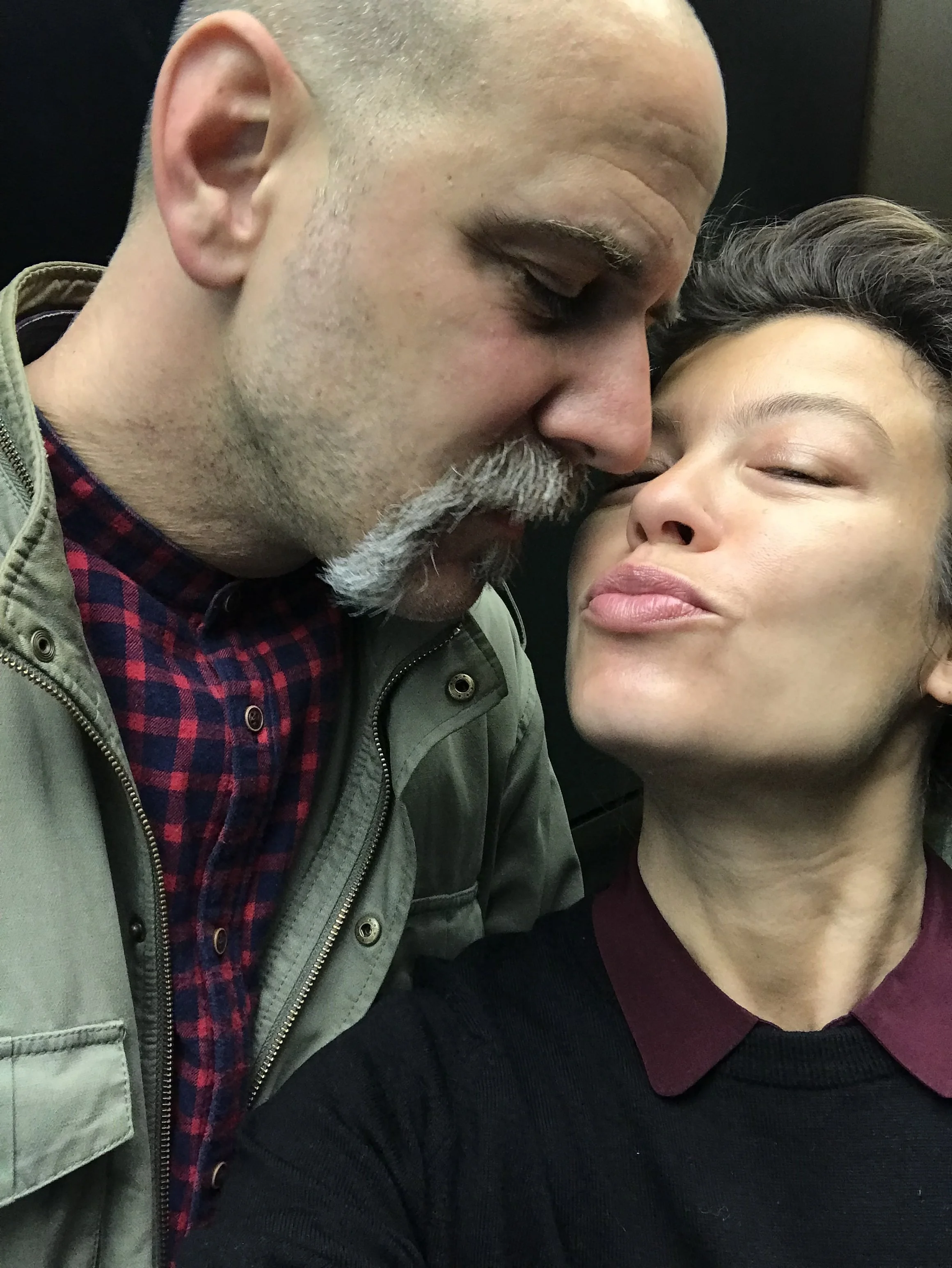 Un uomo e una donna si baciano molto vicini, con il viso quasi a toccarsi, in un'istantanea ravvicinata.