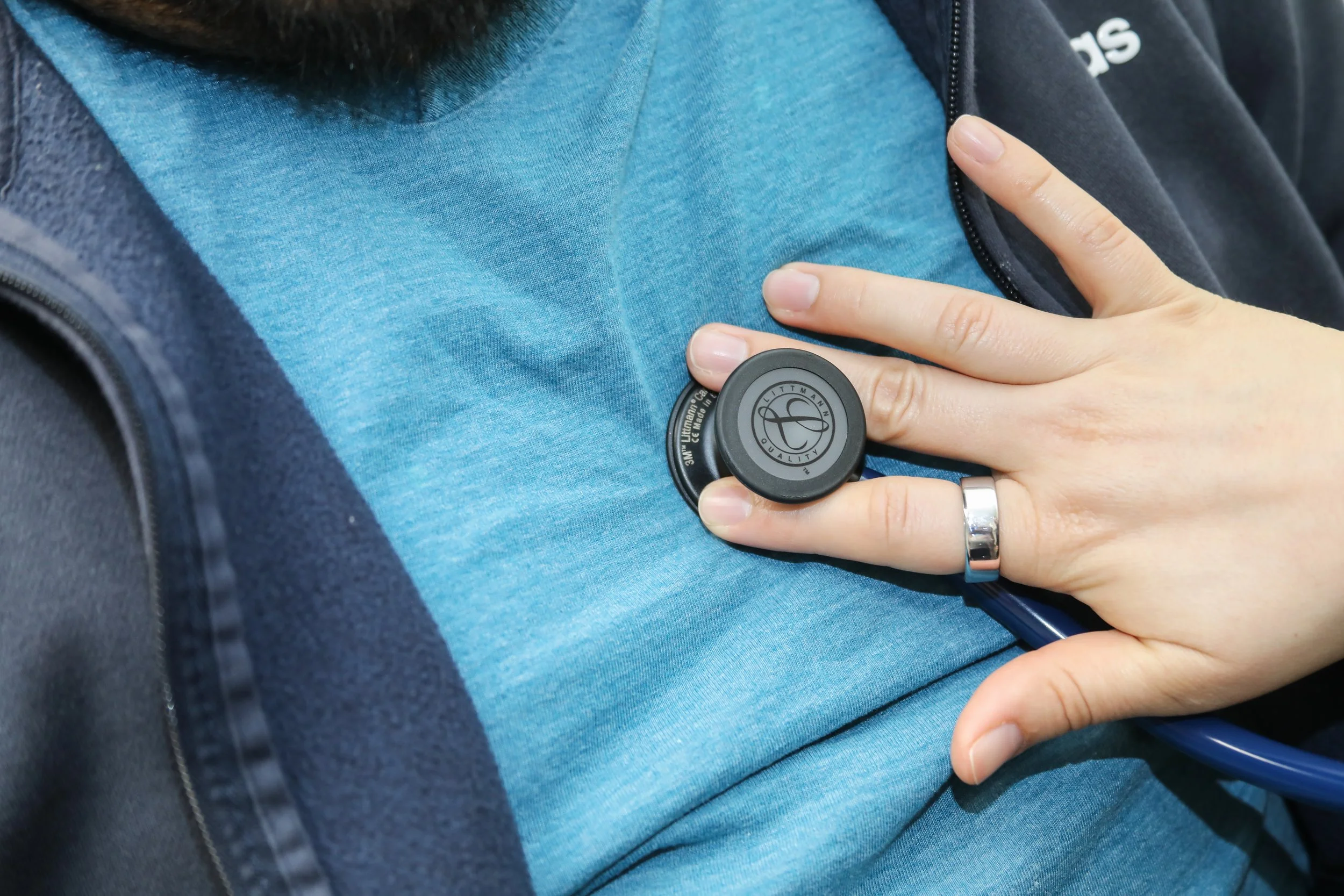 Person placing a stethoscope on their chest.