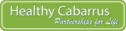 Green sign with white text reading 'Healthy Cabarrus Partnerships for Life'.