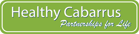 Green rectangular sign with white text saying 'Healthy Cabarrus Partnerships for Life'