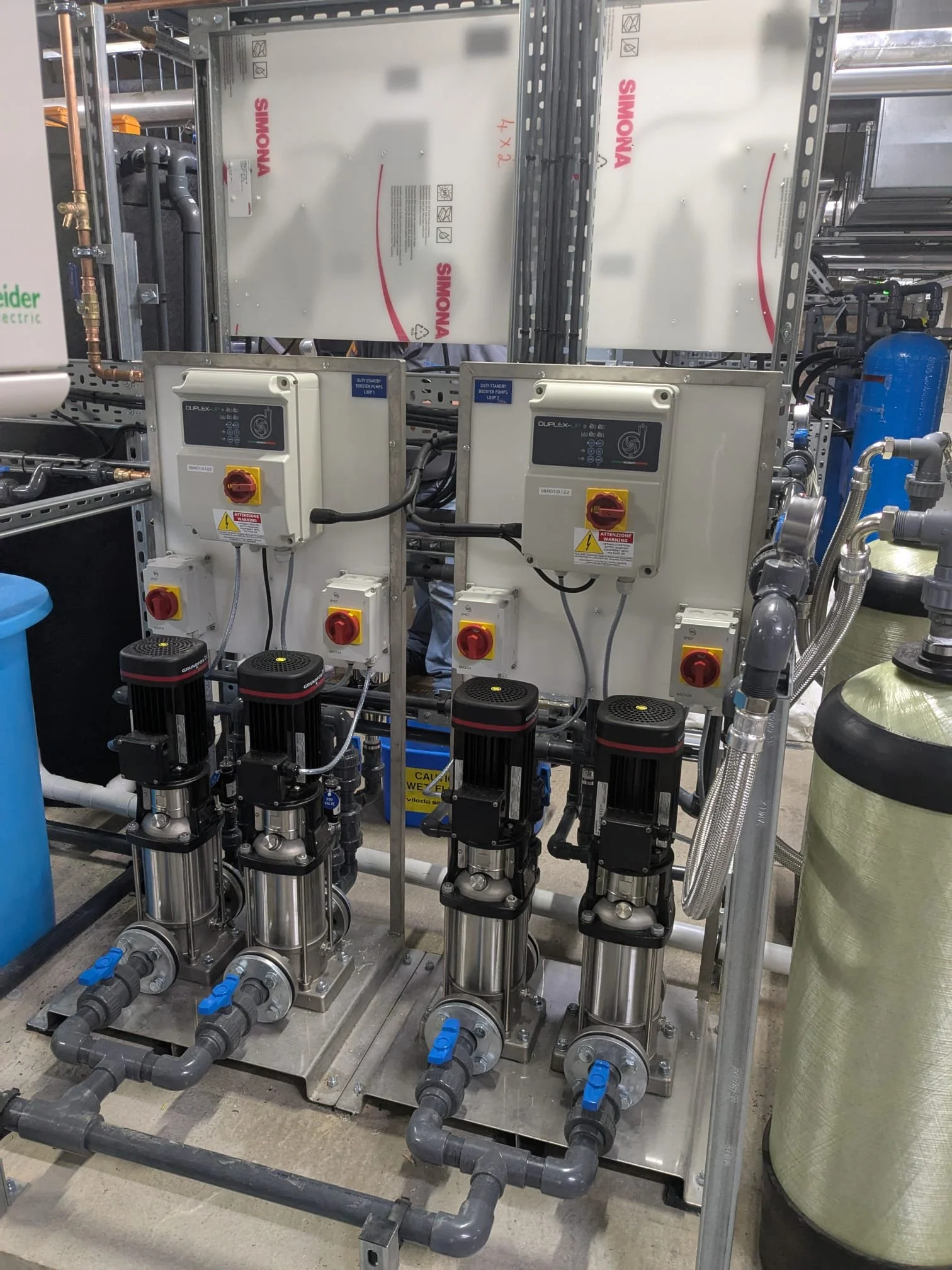 Industrial water filtration system with multiple pumps, control panels, and piping.