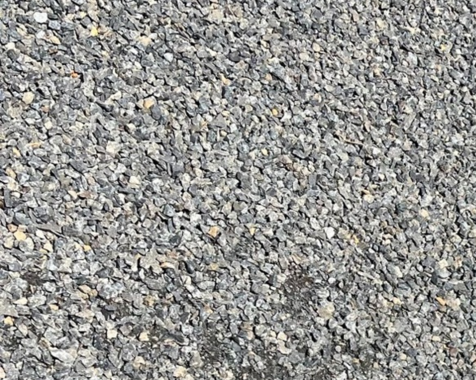 Close-up of gravel ground surface with small gray and tan stones.