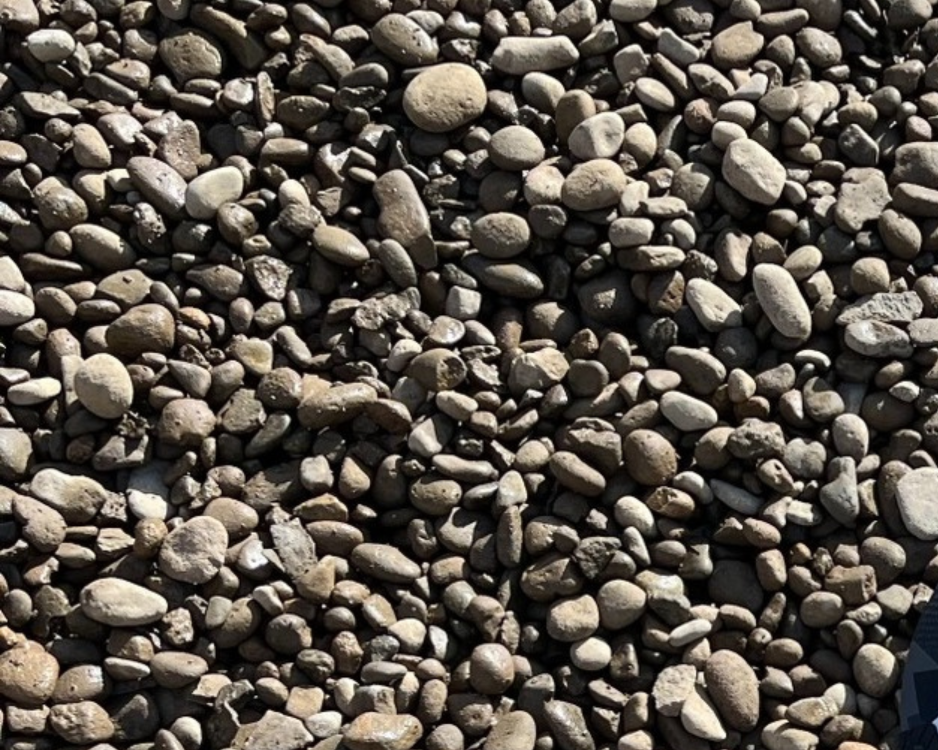 Close-up view of a large collection of small, smooth pebbles and rocks of varying sizes and colors.