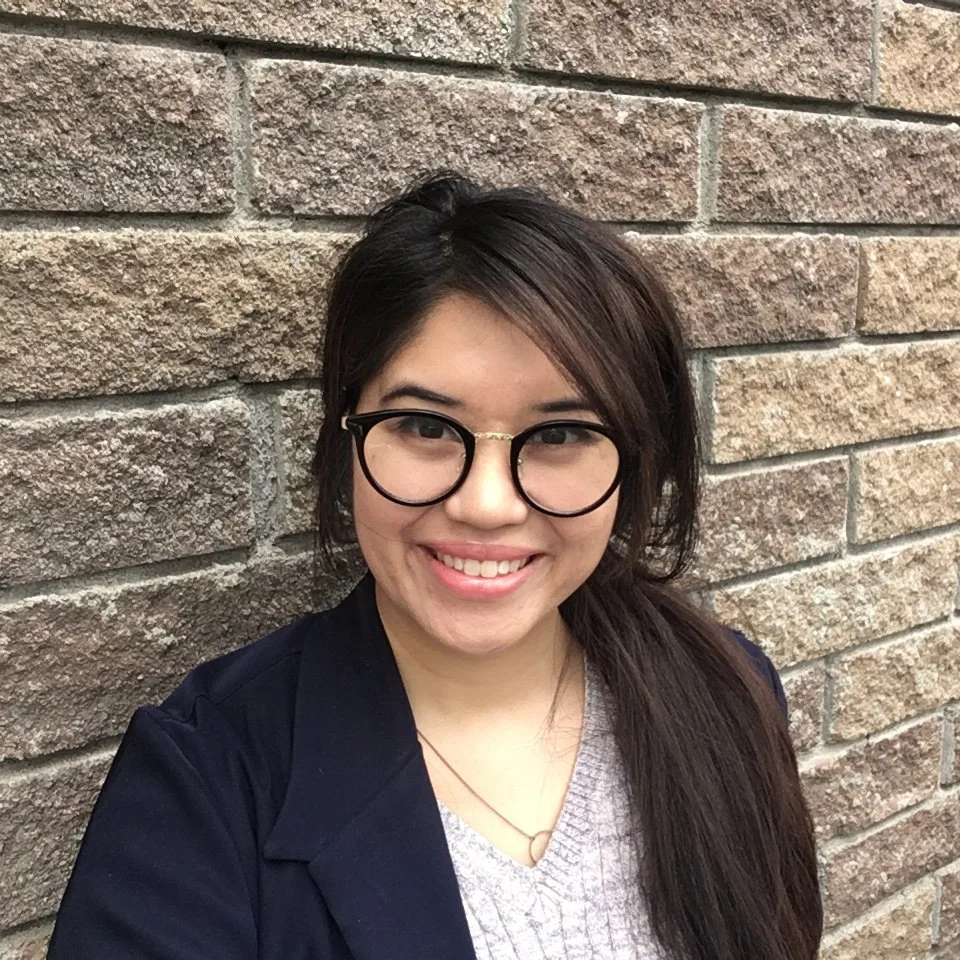 A picture of illustrator, Alannah Bonalos, leaning against a brick wall