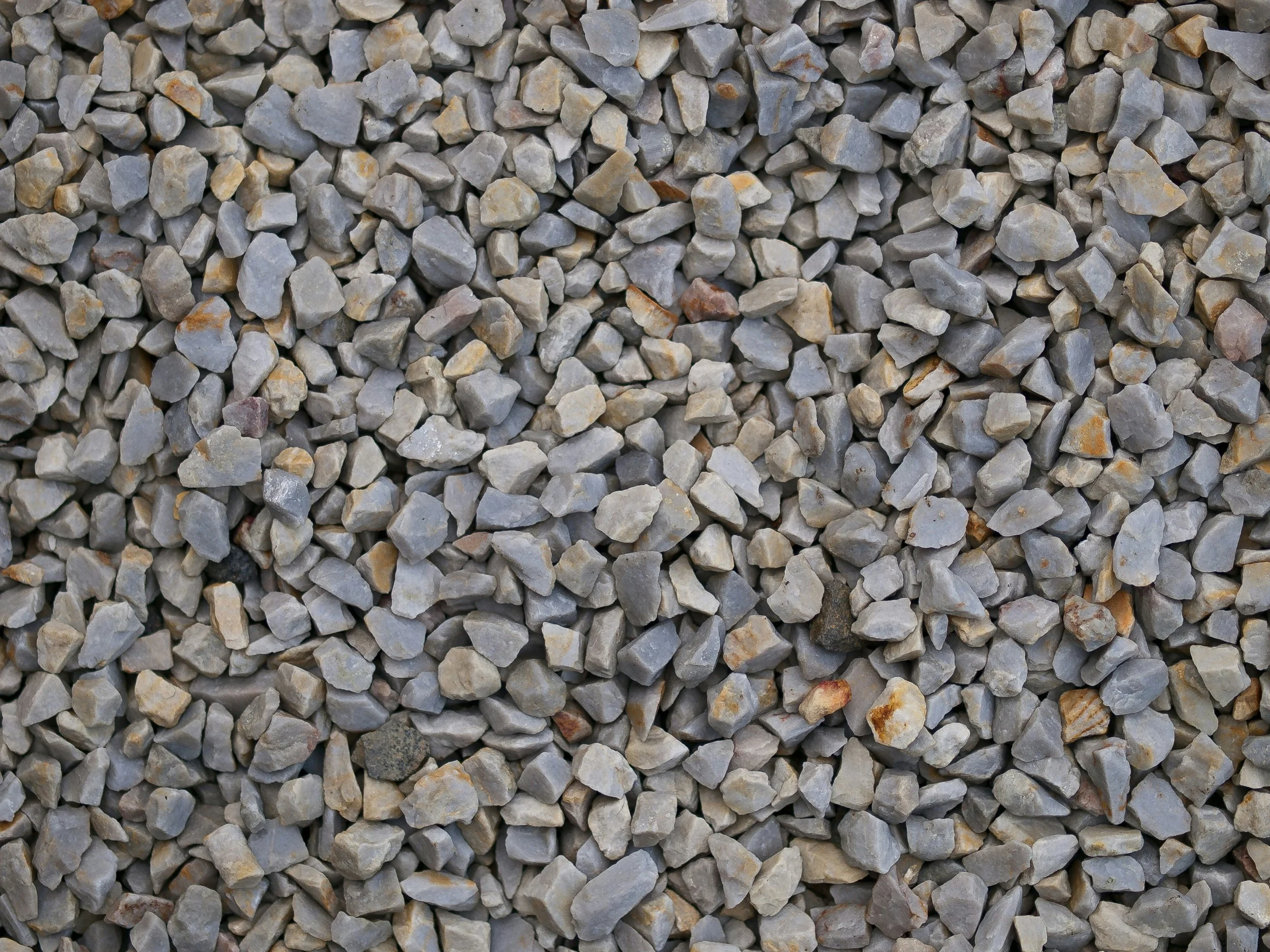 Close-up of small gravel stones in various shades of gray and tan.