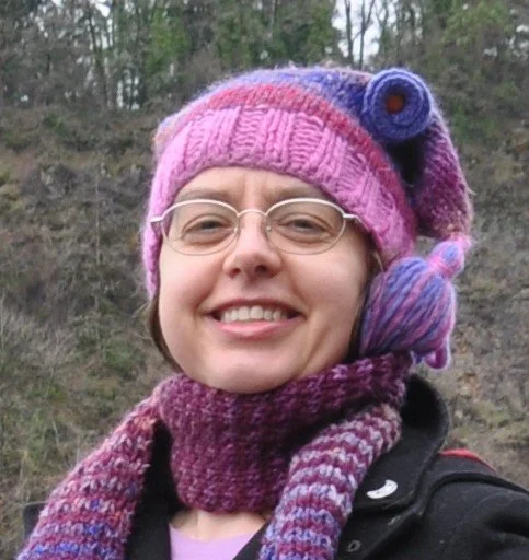Happy smiling woman Stephanie with glasses, beanie, and scarf