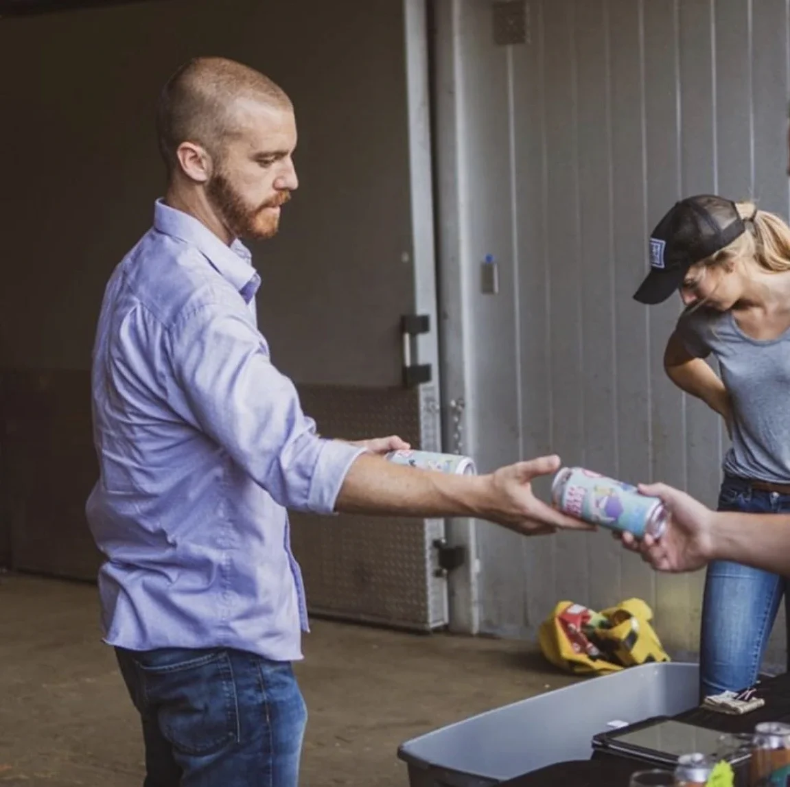 Beverage brand leader handing out cans during a consulting partnership and collaboration.