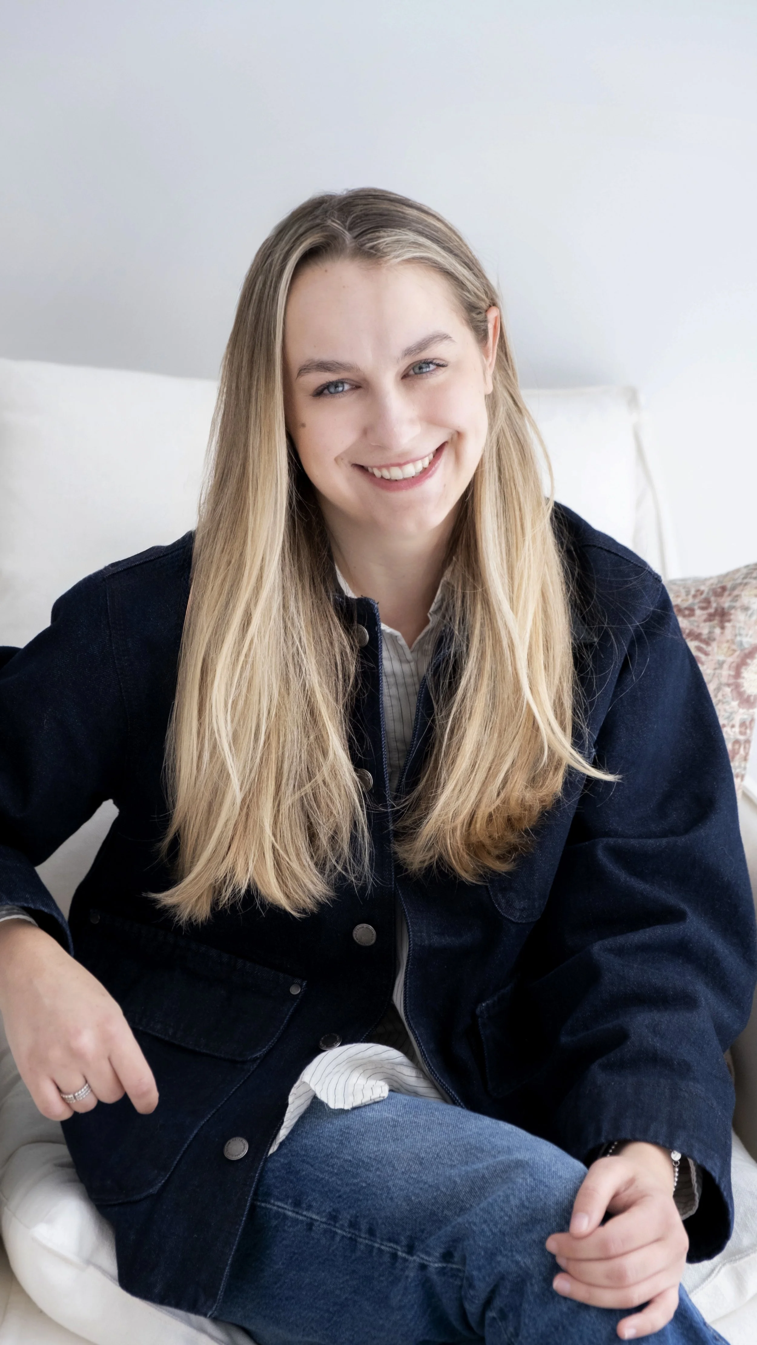 Portrait professionnel d'Alexya Robert, fondatrice et designer d'intérieur de Studio Lagom, souriante et posant naturellement dans un espace lumineux.