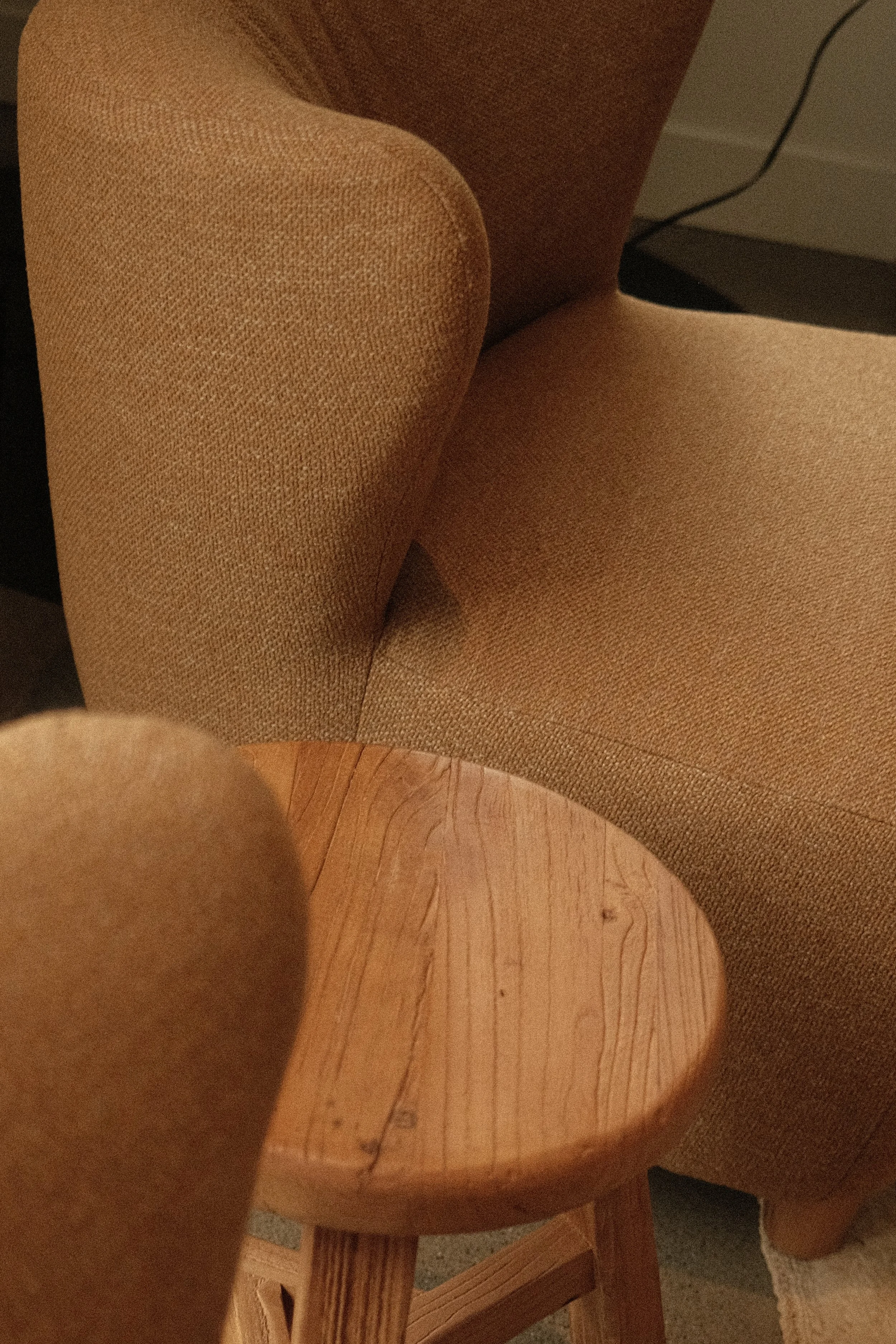 Fauteuil en tissu beige et table d’appoint en bois dans un aménagement intérieur chaleureux signé Studio Lagom