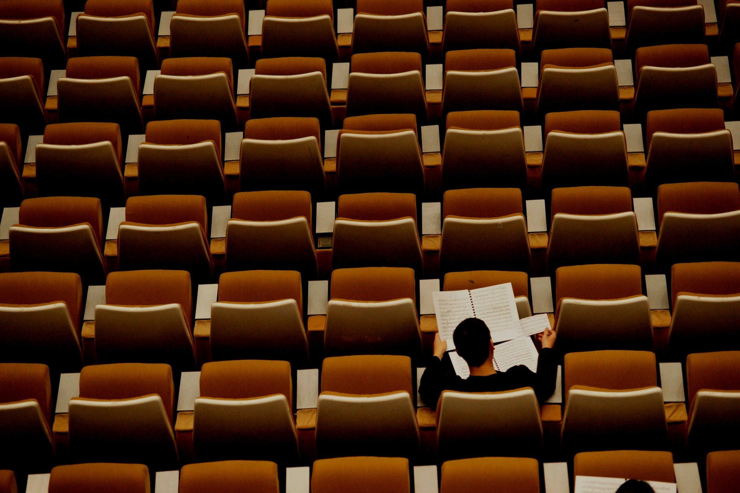College student in an empty lecture hall preparing for first-year academics