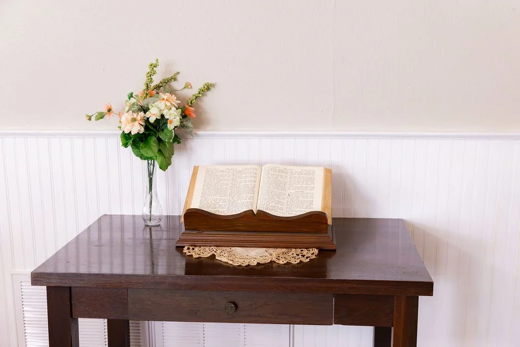 A wooden table with a Bible open, representing the Bible as our guidebook and authority in both religion and in daily Christian living.