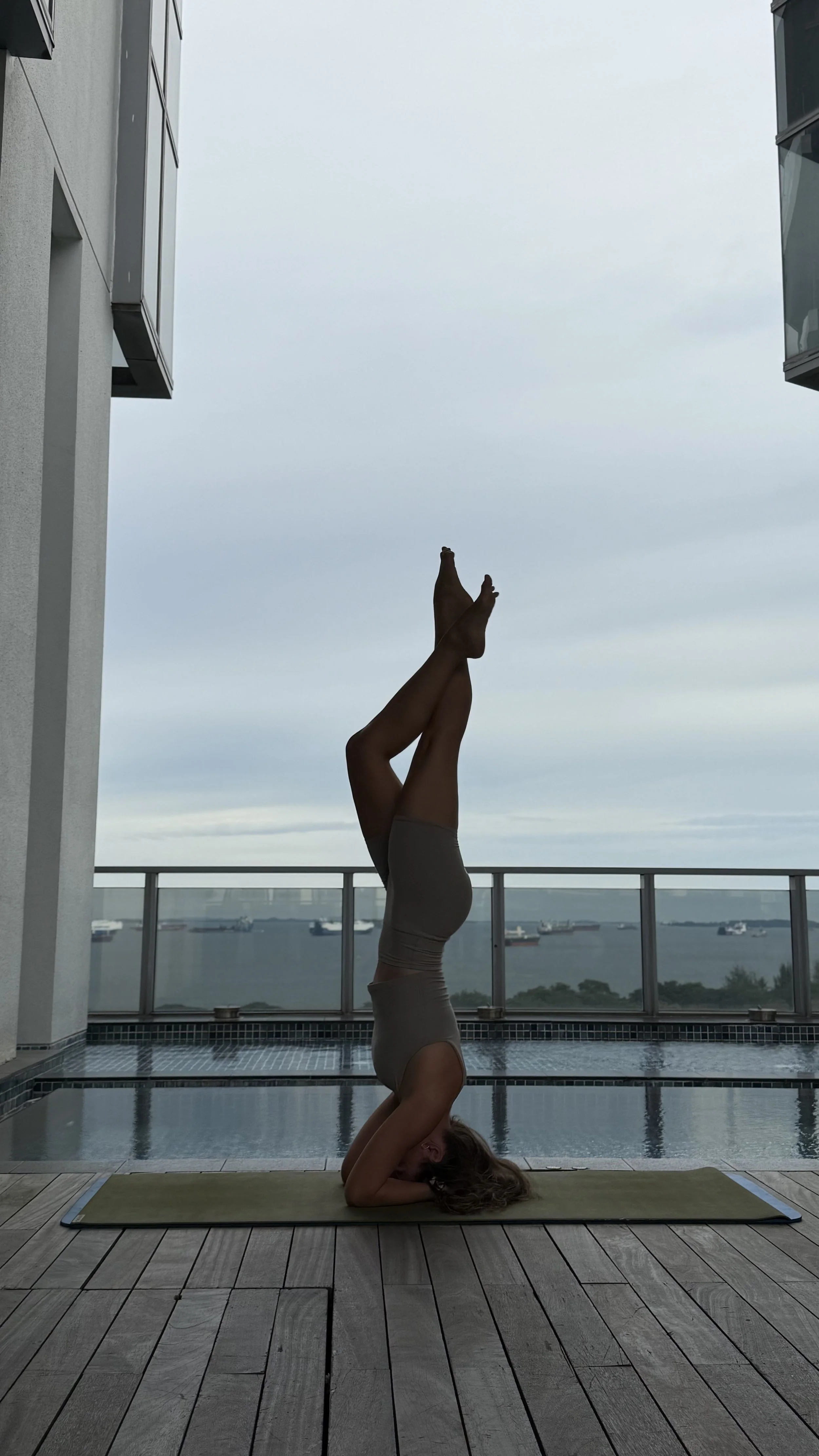Alina on the yoga mat doing yoga inversion
