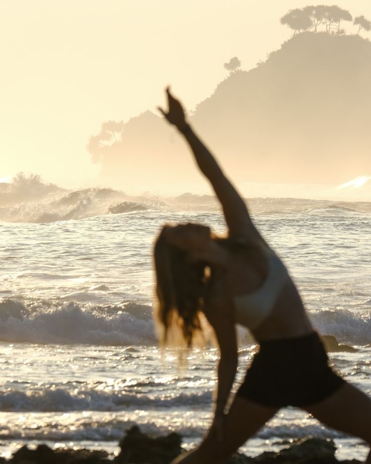 girl doing yoga at the beach