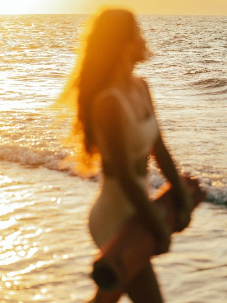 girl walking at the beach with yoga mat