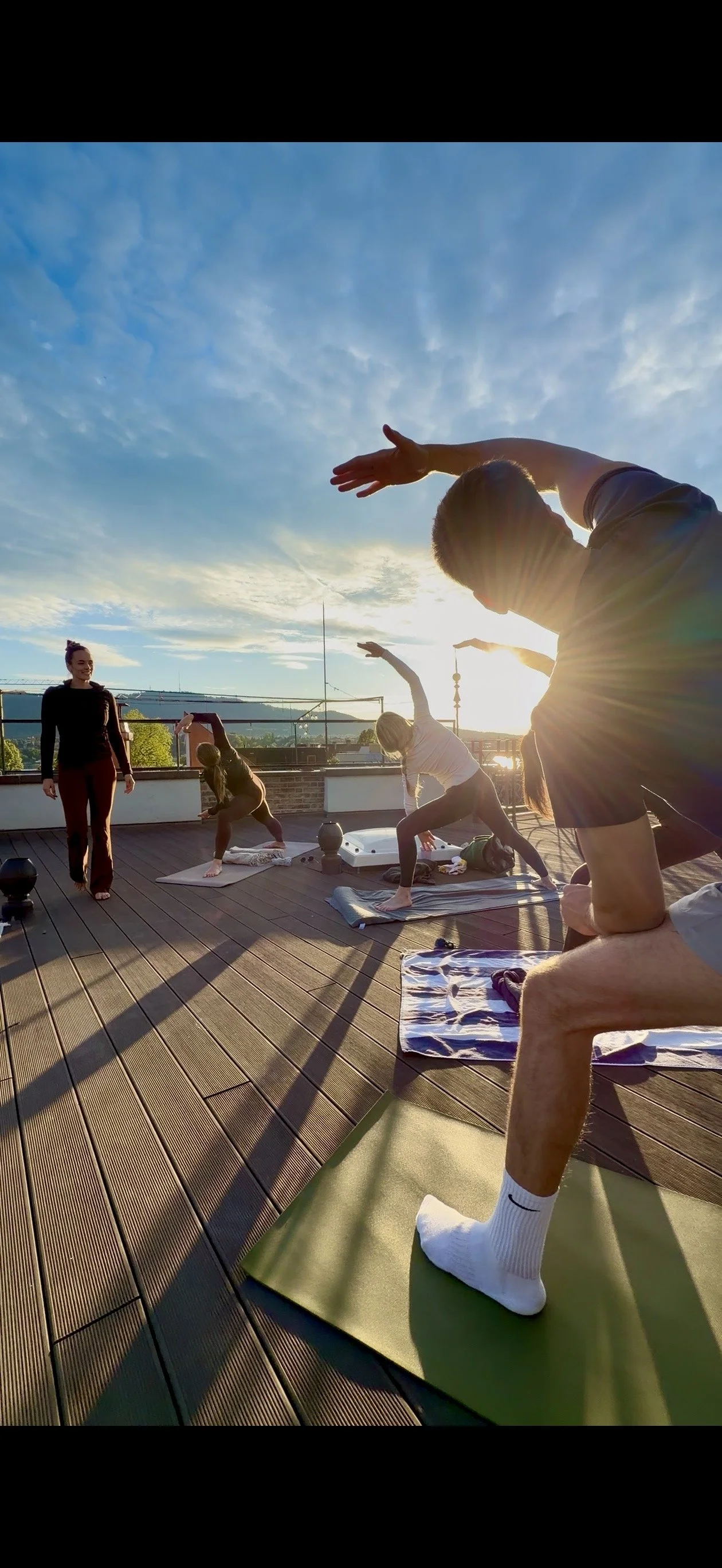 Group of people doing yoga on rooftop terrace in Zurich