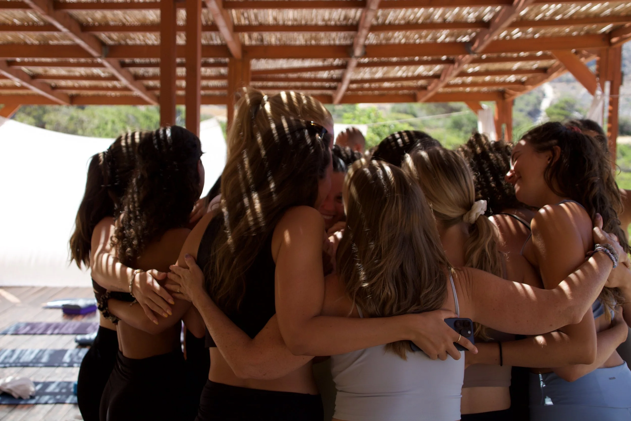 A group of friends hugging themselves on the yoga deck