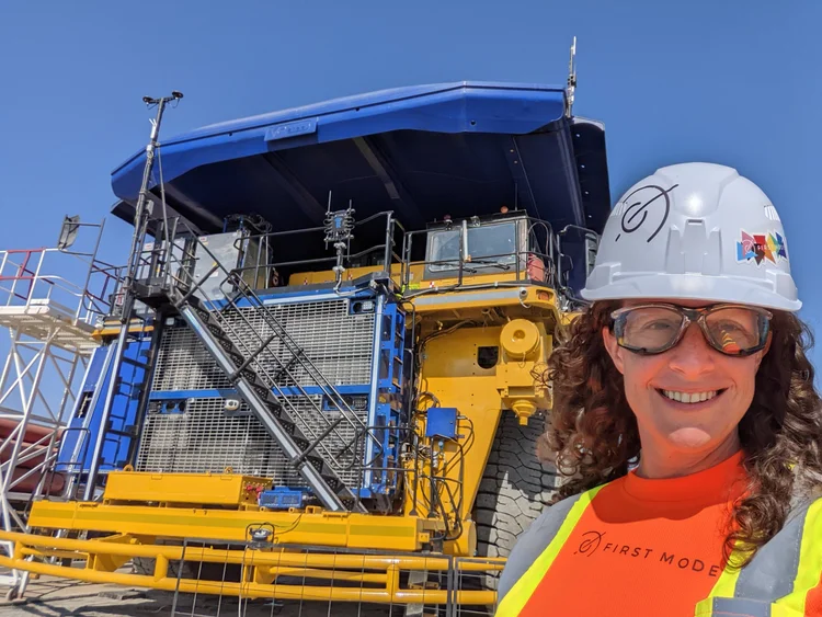 Maggie Scholtz in a hard hat in front of a mining haul truck, during her time at First Mode