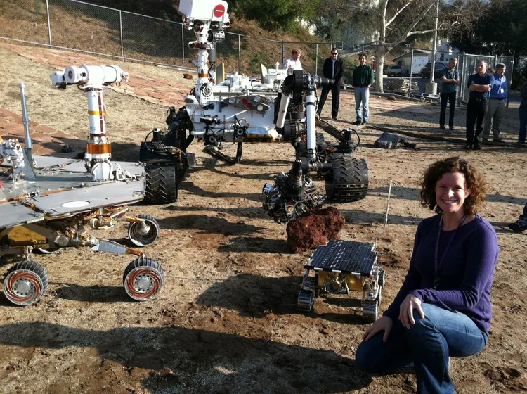 Maggie Scholtz with Mars rover test models in a rover test yard