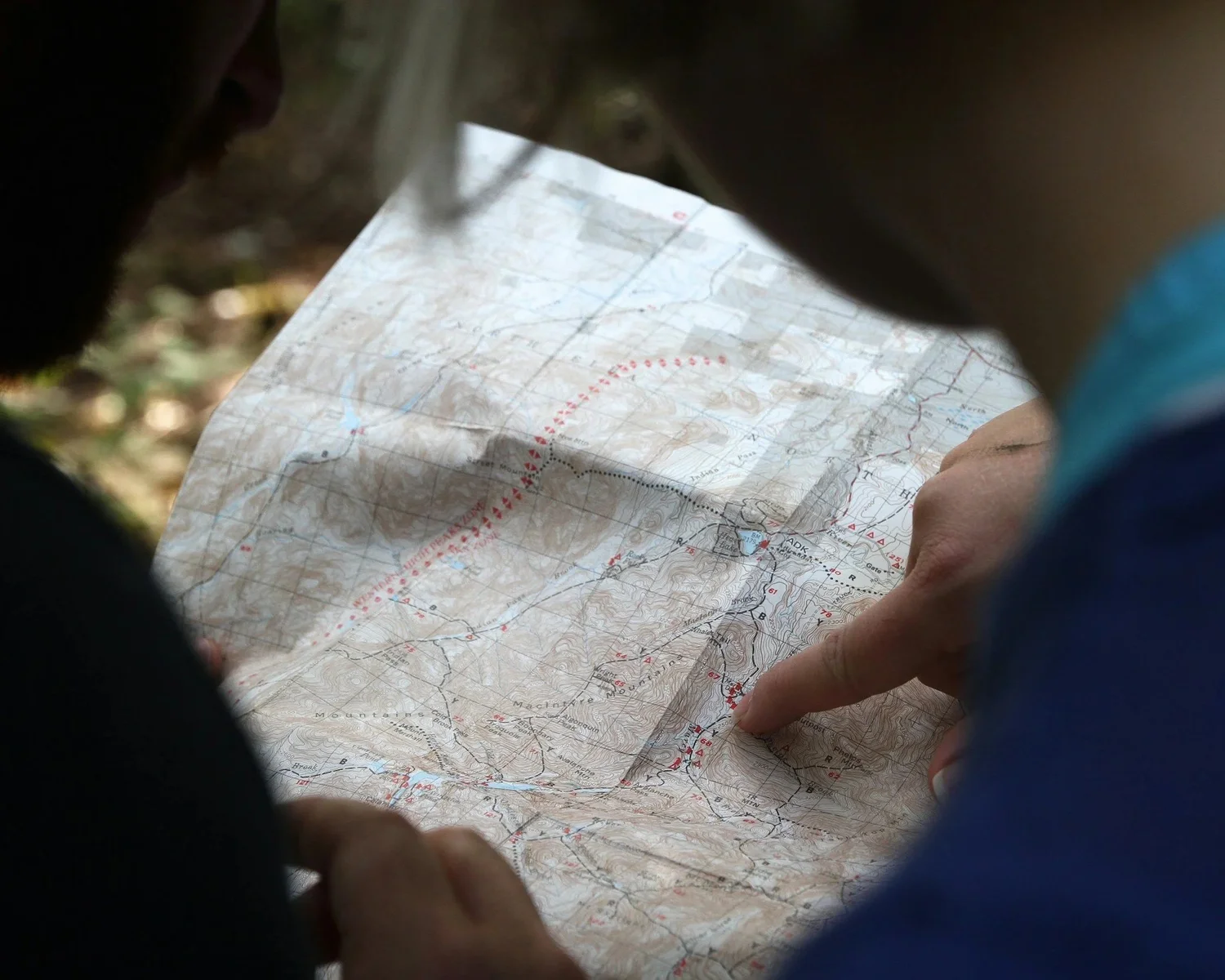 Two people tracing a route on a paper map