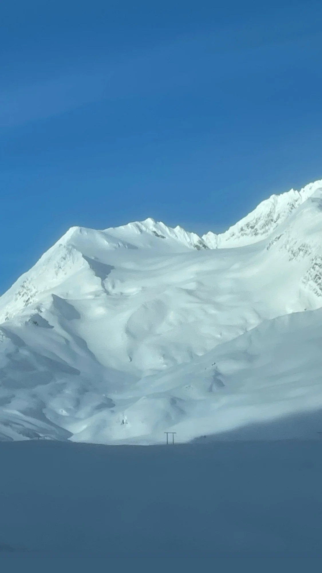 Snow-covered mountain landscape with a clear blue sky. loveland