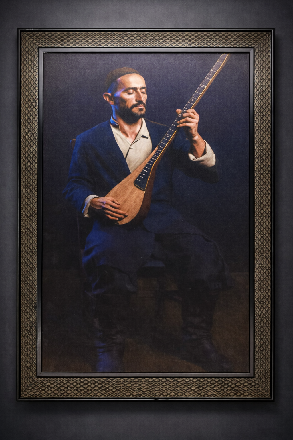 A framed portrait of a man with a beard playing a traditional stringed instrument, sitting with closed eyes in a dark setting.
