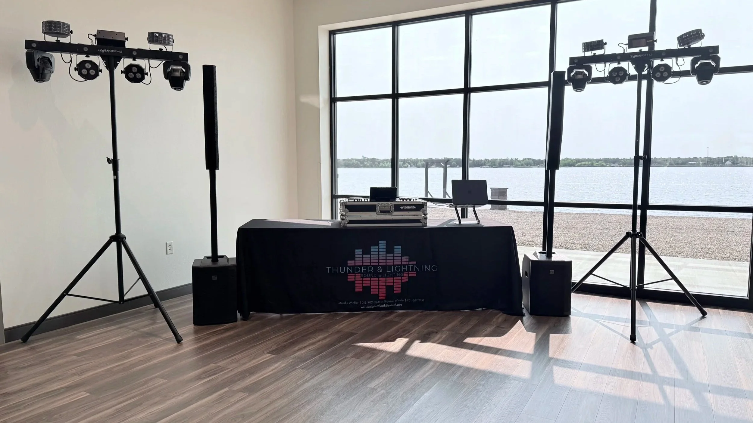 Indoor DJ setup with professional lighting and sound equipment near large windows overlooking Devils Lake, North Dakota.  At Woodland Resort.