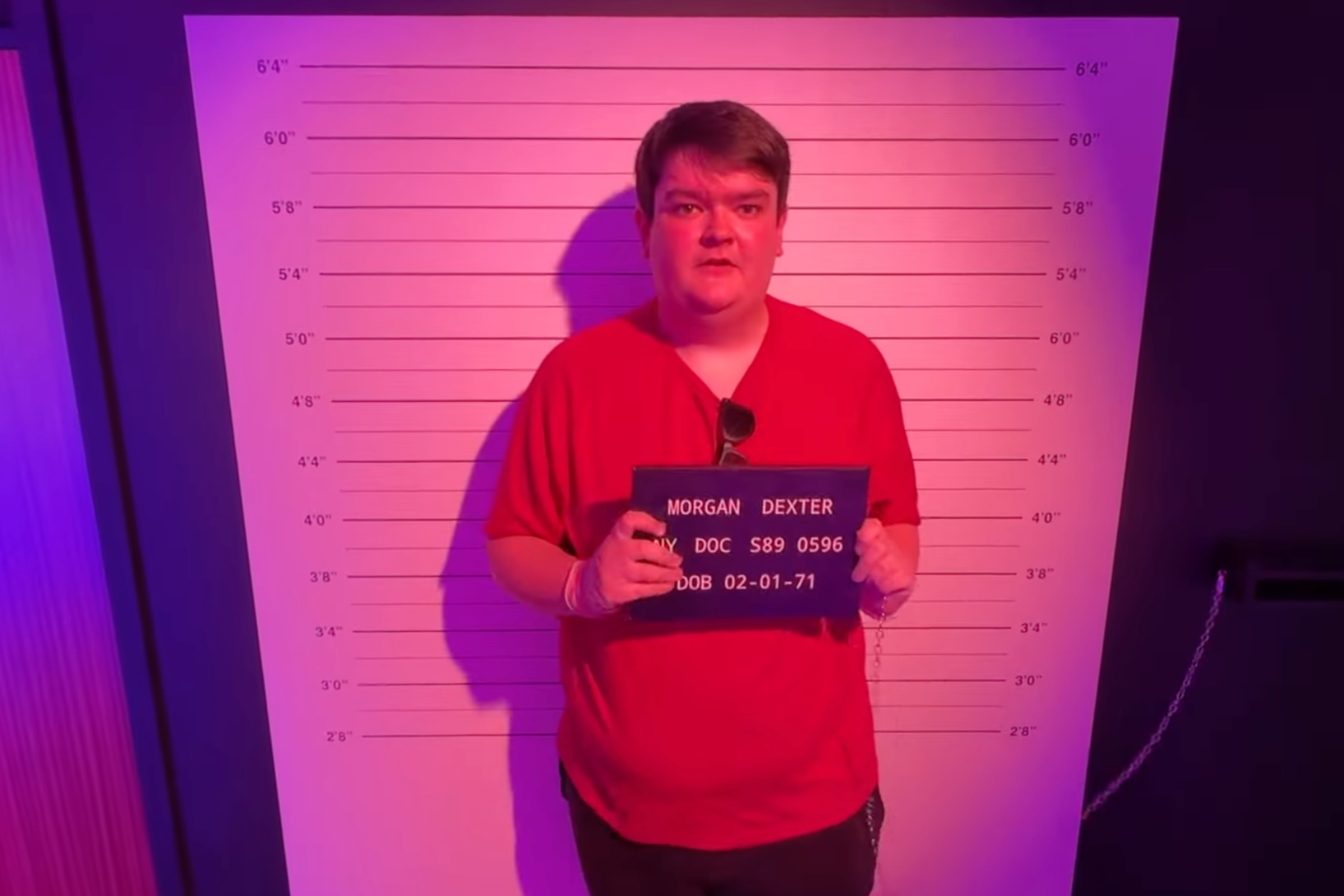 British YouTuber poses for a mug shot at Dexter: The Experience in London