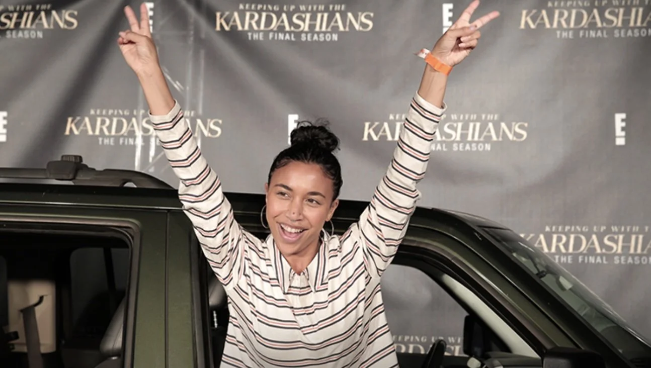 A fan poses outside of a car window at the Kardashians Drive-In Premiere Screening