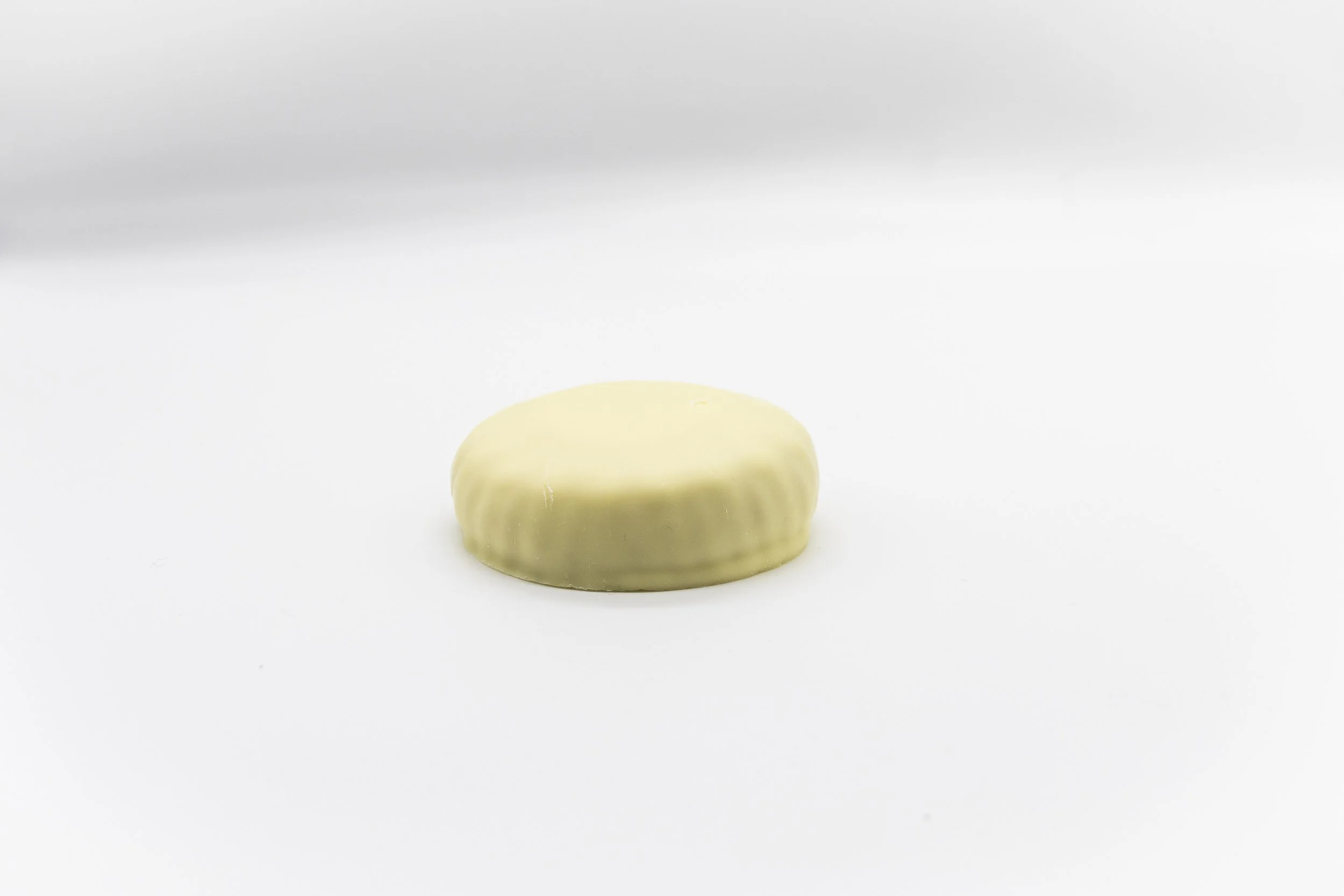 A white chocolate piece on a plain white background