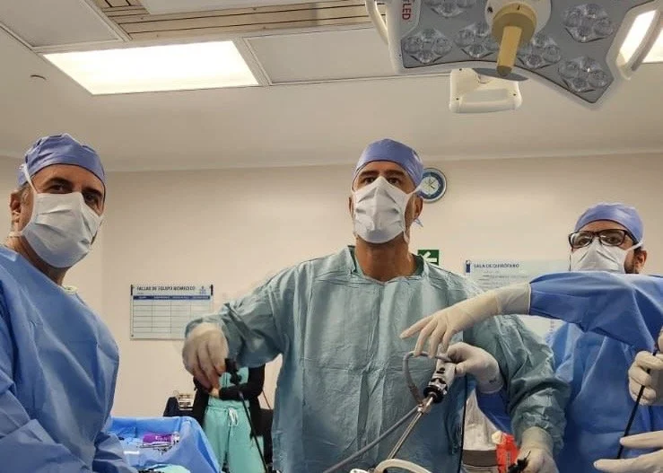 Personal médico en un quirófano realizando un procedimiento quirúrgico con equipo médico y quirúrgico.