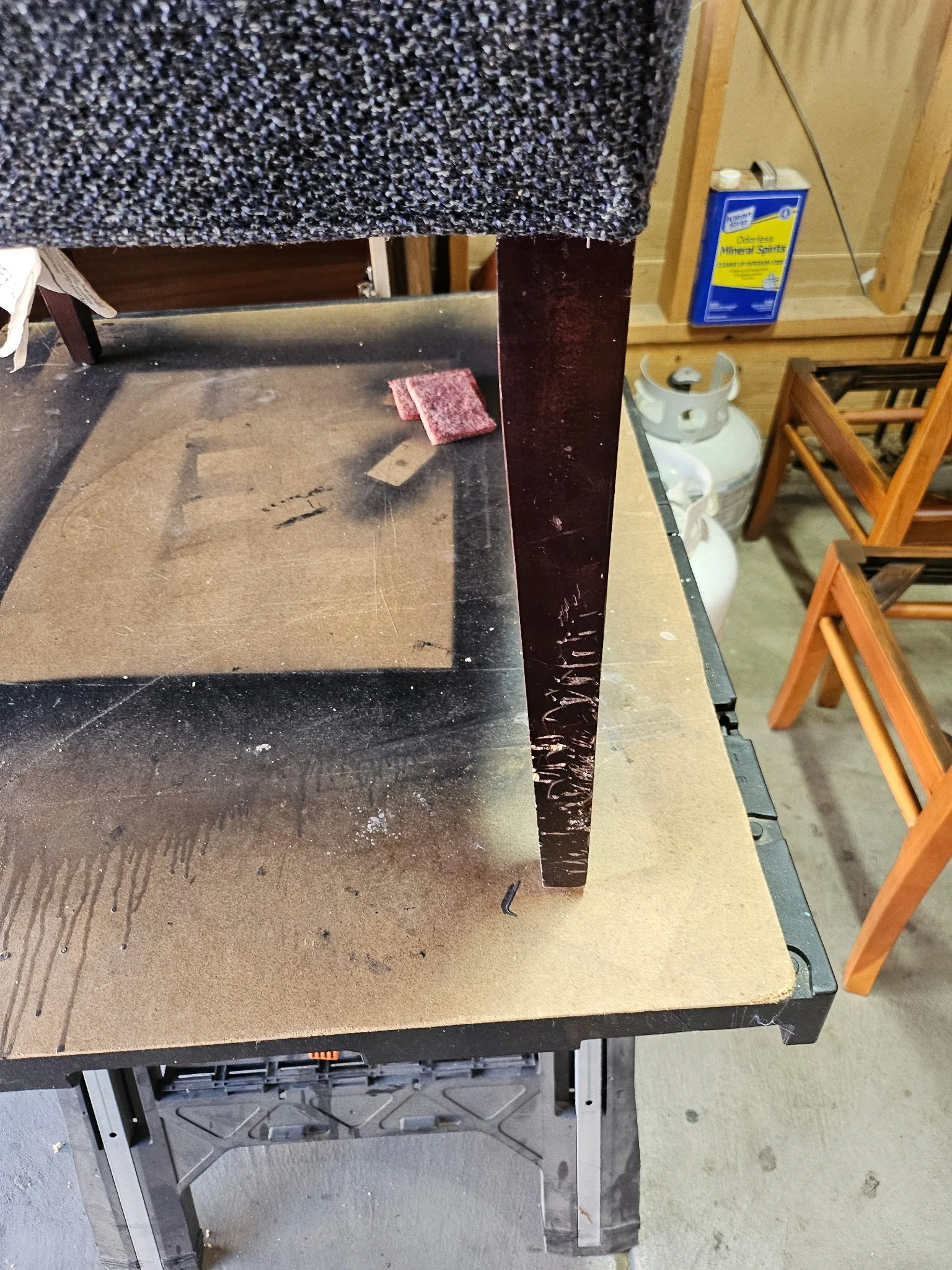 Dark wood chair frame with worn and damaged finish before repair