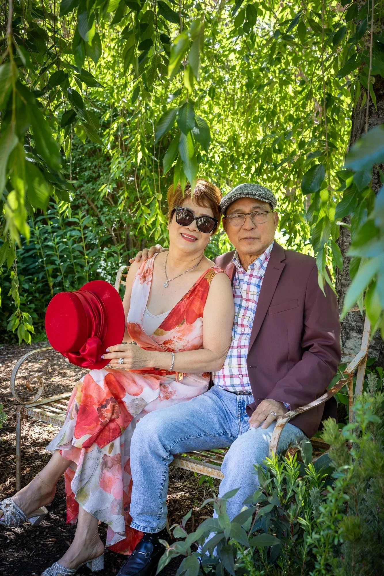 Older couple on bench under willow tree at Filoli Gardens, intimate spring portrait Bay Area