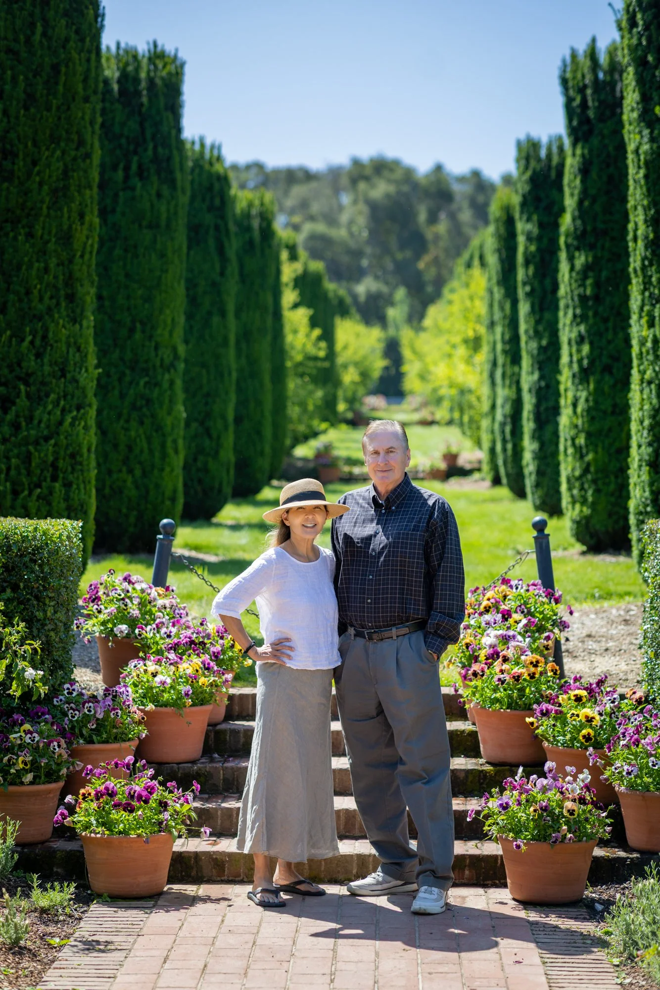 Couple on the formal garden steps at Filoli lined with terracotta pansy pots, Woodside California