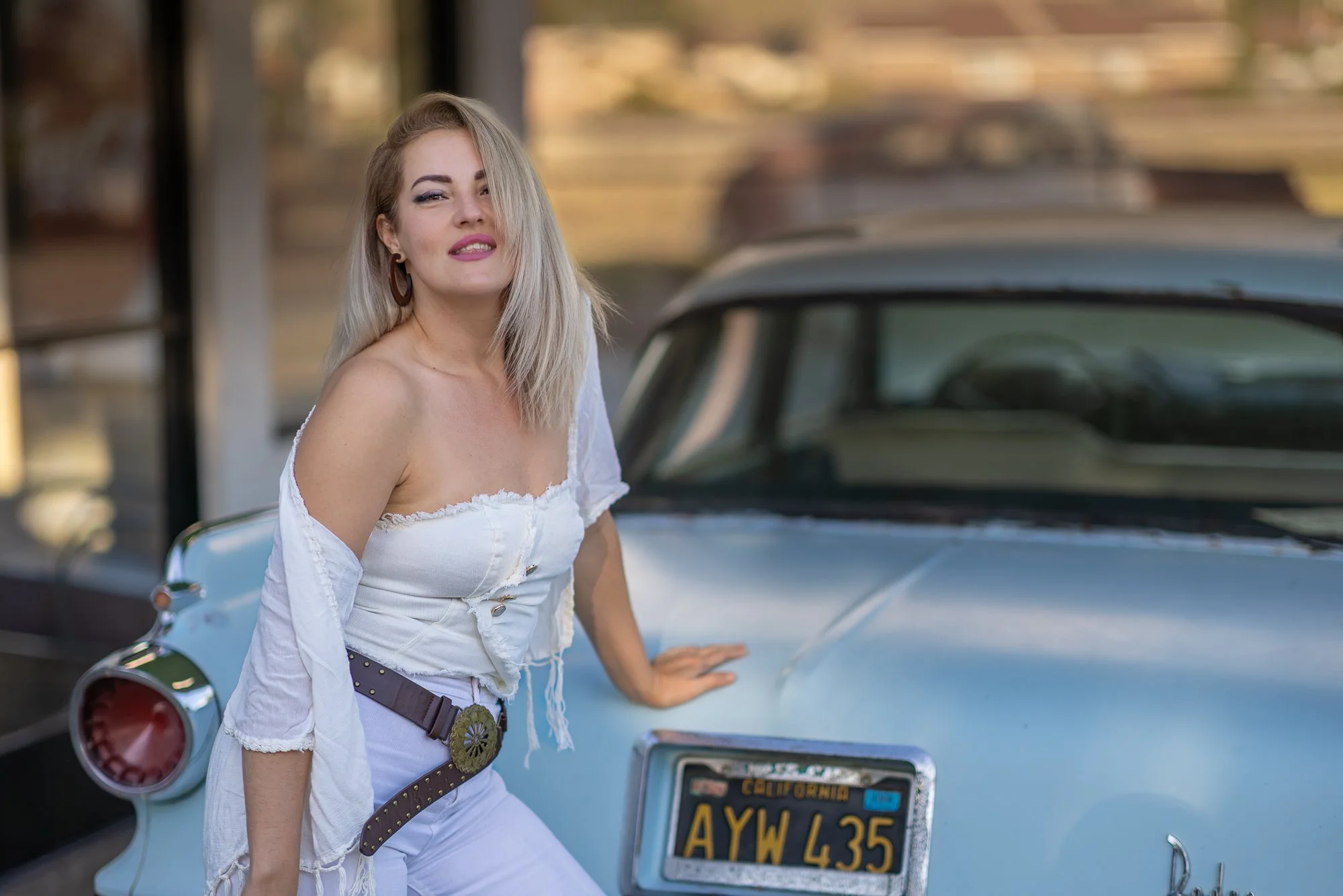 Woman in white corset and jeans leaning against vintage Model T truck at Niles Flying A, Fremont, natural light editorial portrait