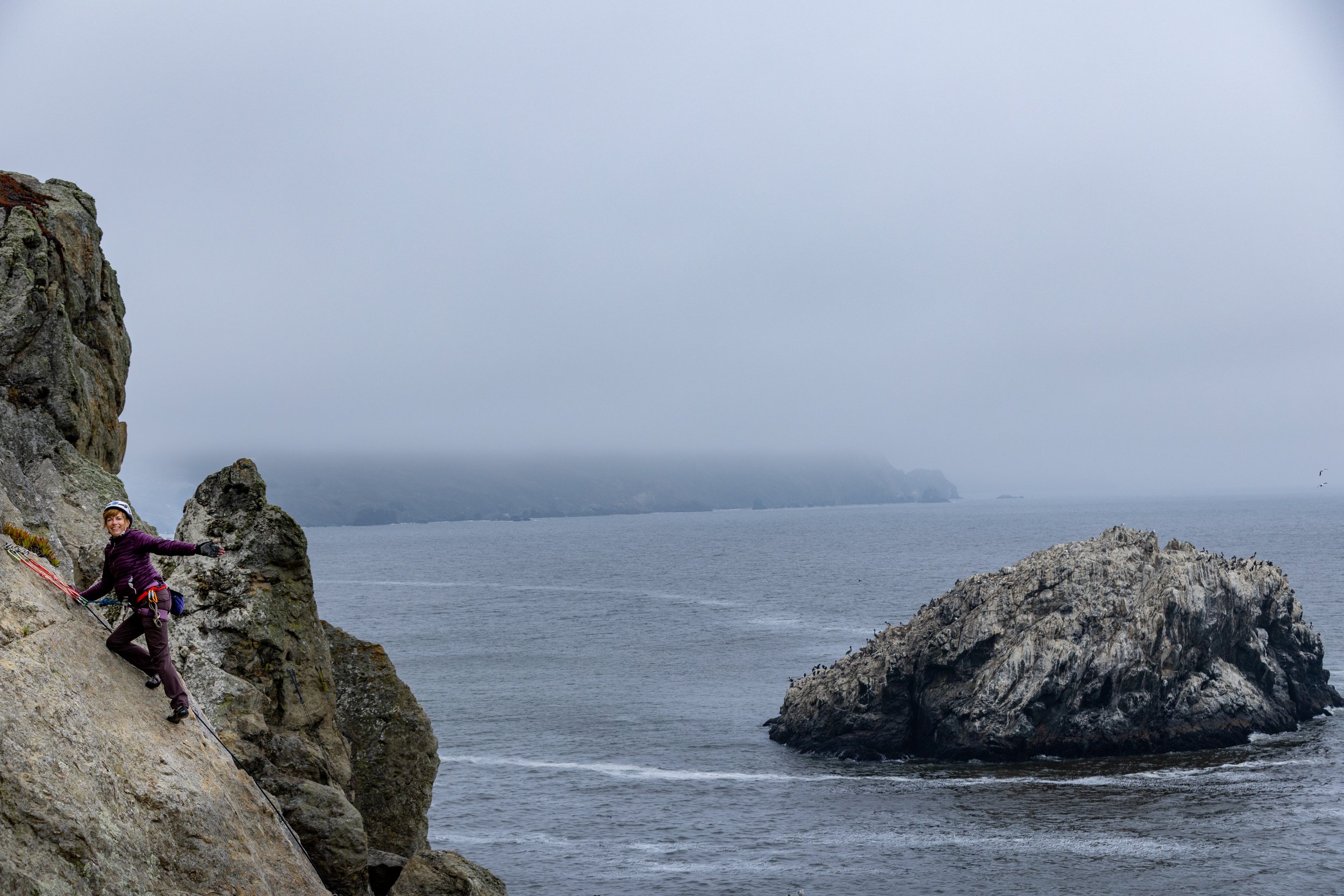 Bay Area Rock Climbing Action Photo - woman climbing over ocean