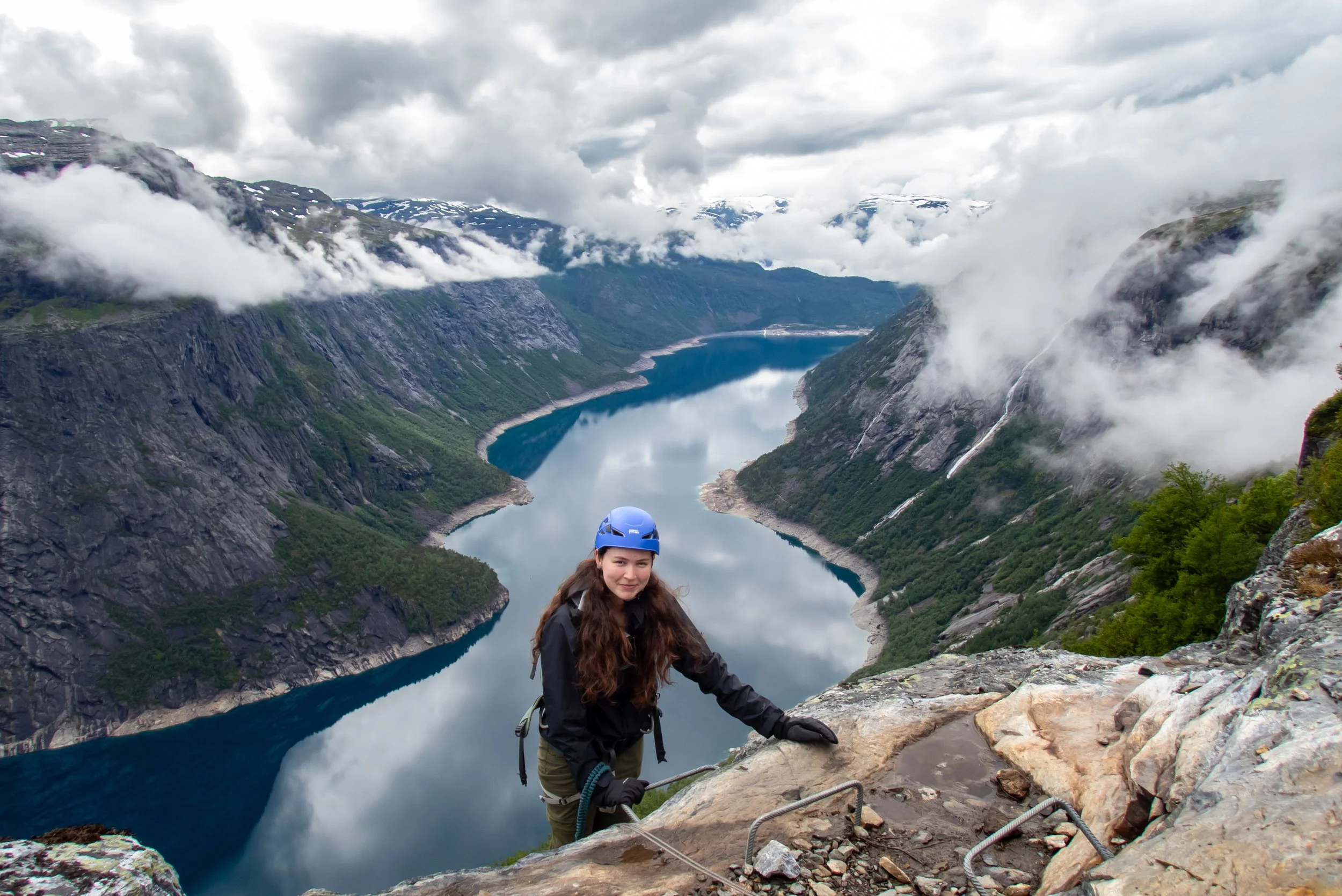 Hiker standing on a rocky outcrop overlooking the valley, catching their breath.