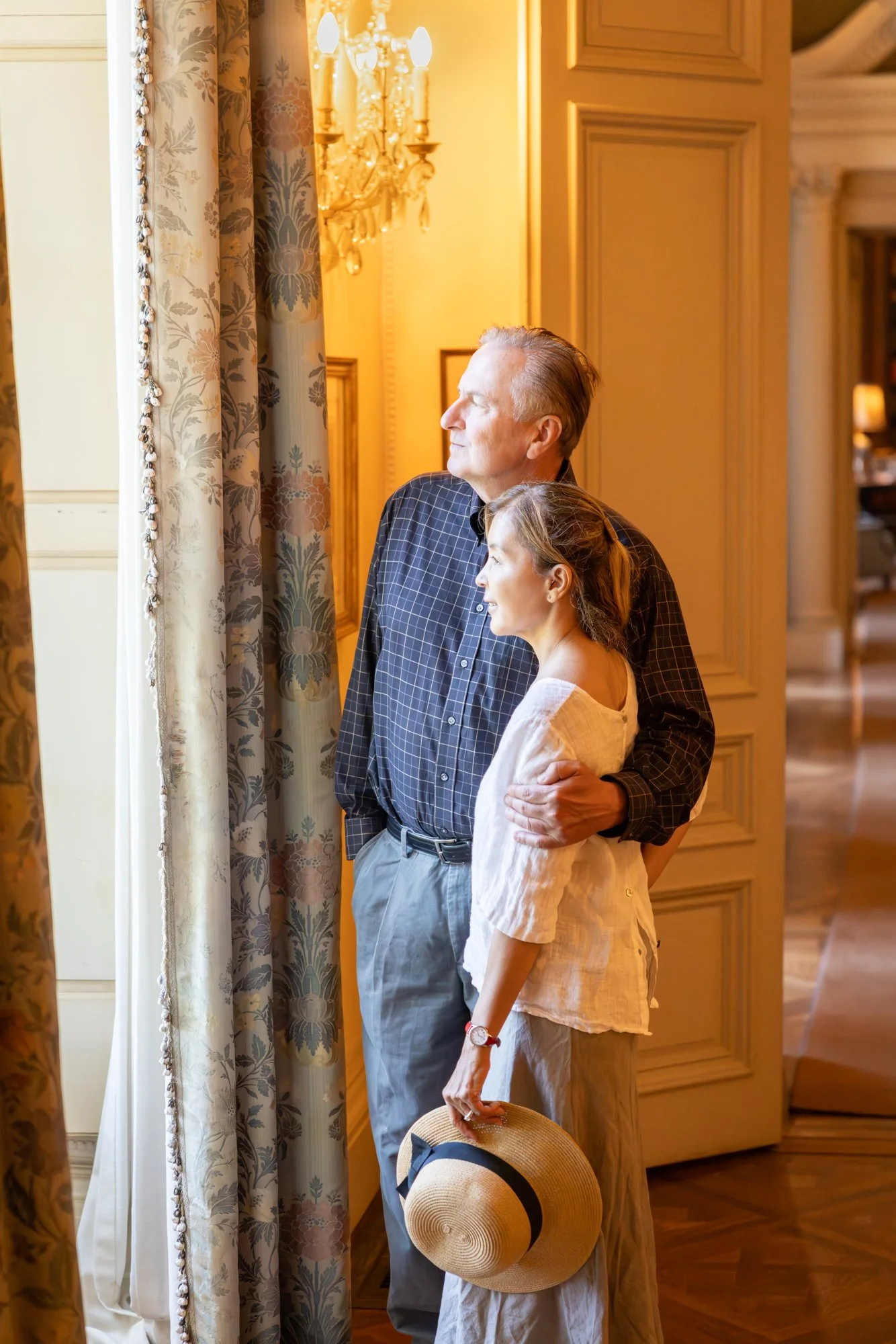 Couple by a tall draped window inside the Filoli historic house, warm afternoon light, Woodside